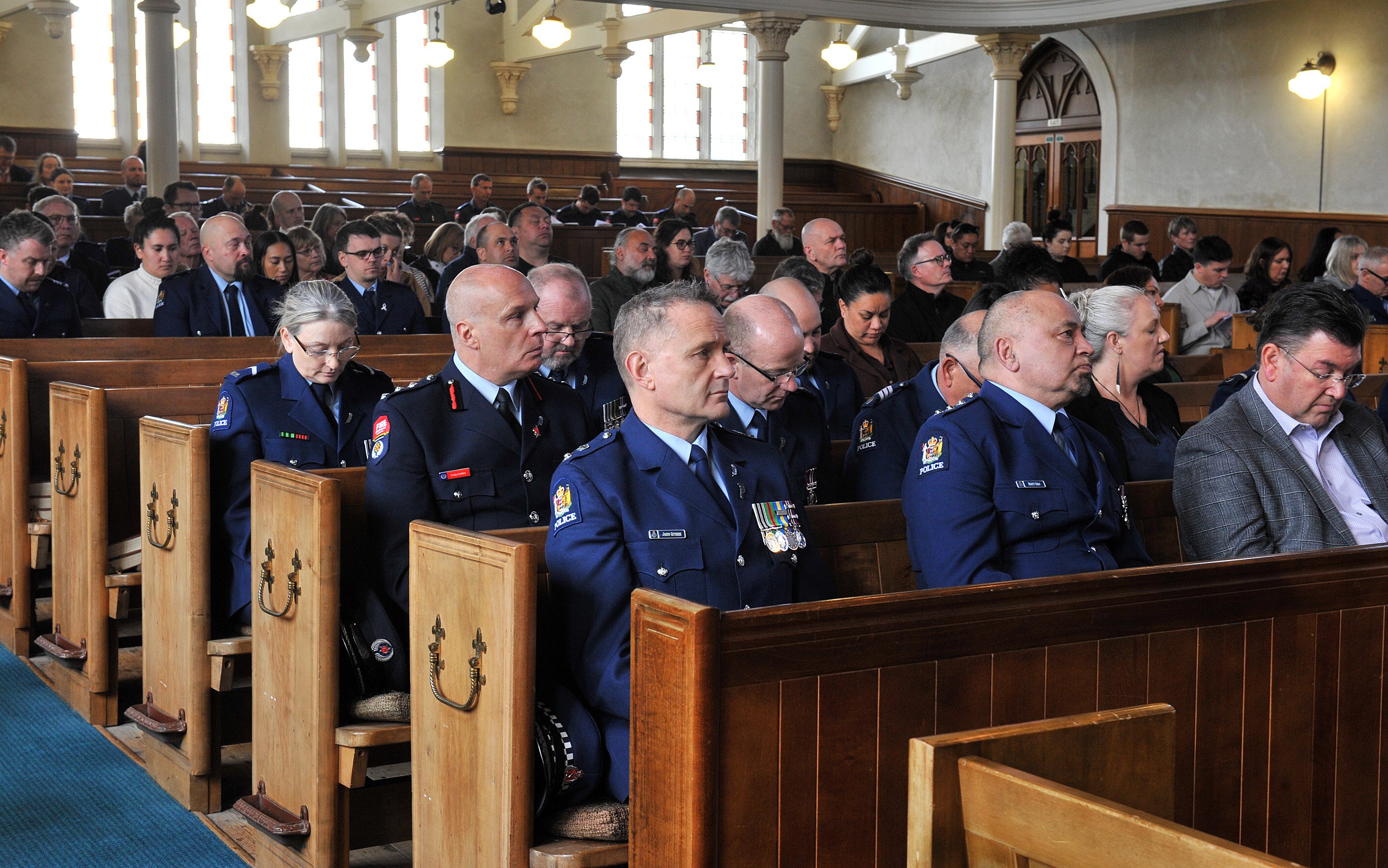 Members of the police listen as a roll of honour is read aloud to commemorate officers who died...