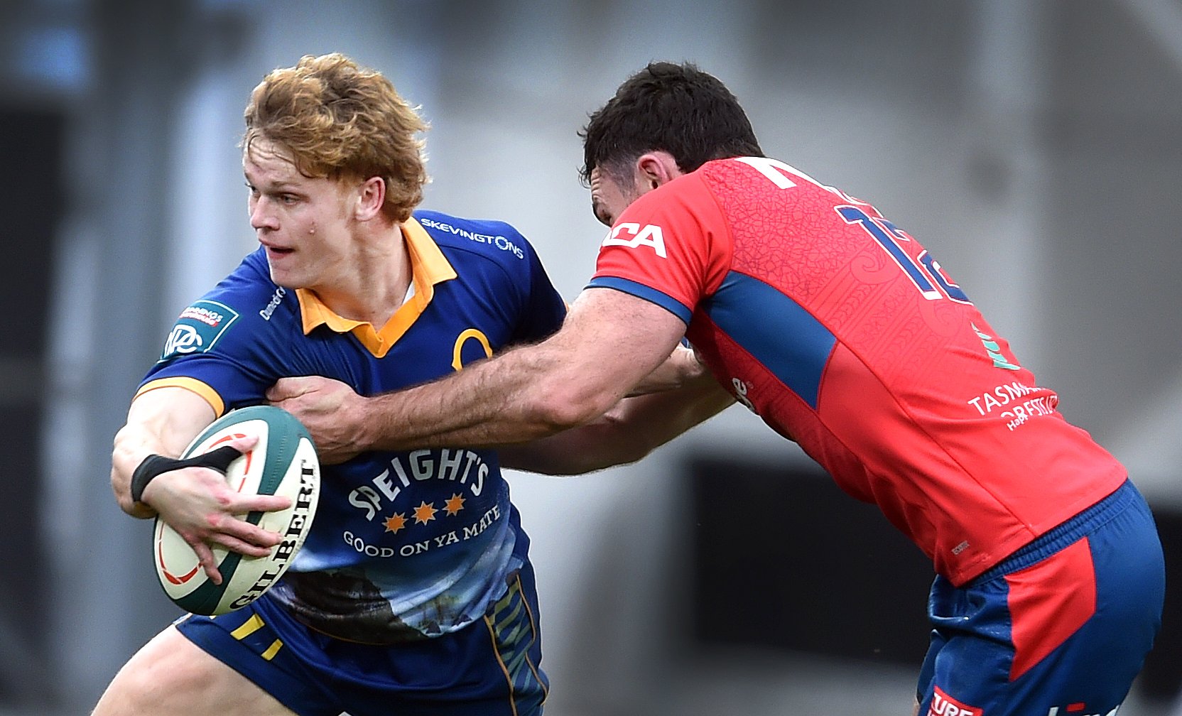 Otago fullback Finn Hurley is held by Tasman second five Tim O'Malley during the NPC match at...