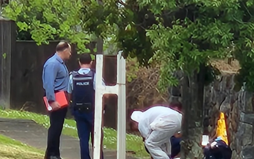 Police officers, some in forensic suits, collect samples from the scene. Photo: RNZ 