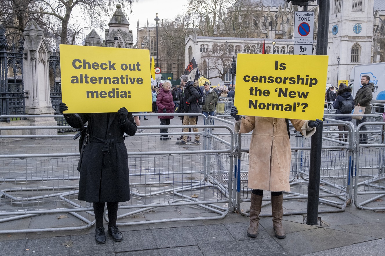 An antivax conspiracy believer casts doubt on the mainstream media while protesting a Covid-19...