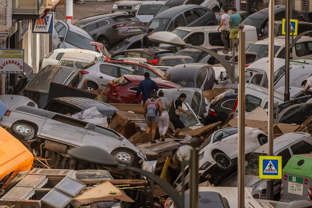 Cars are piled in the street with other debris in the Sedaví area of Valencia after flash floods...