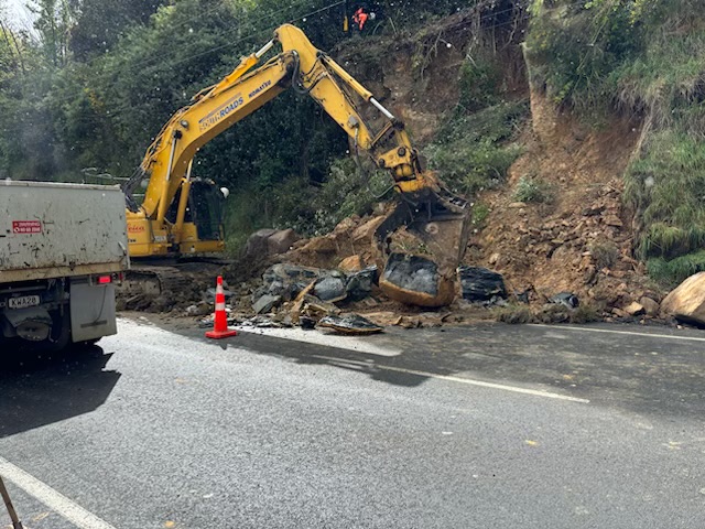 Contractors work to remove some of the boulders that fell onto SH88 near Parry St. Photo: NZTA