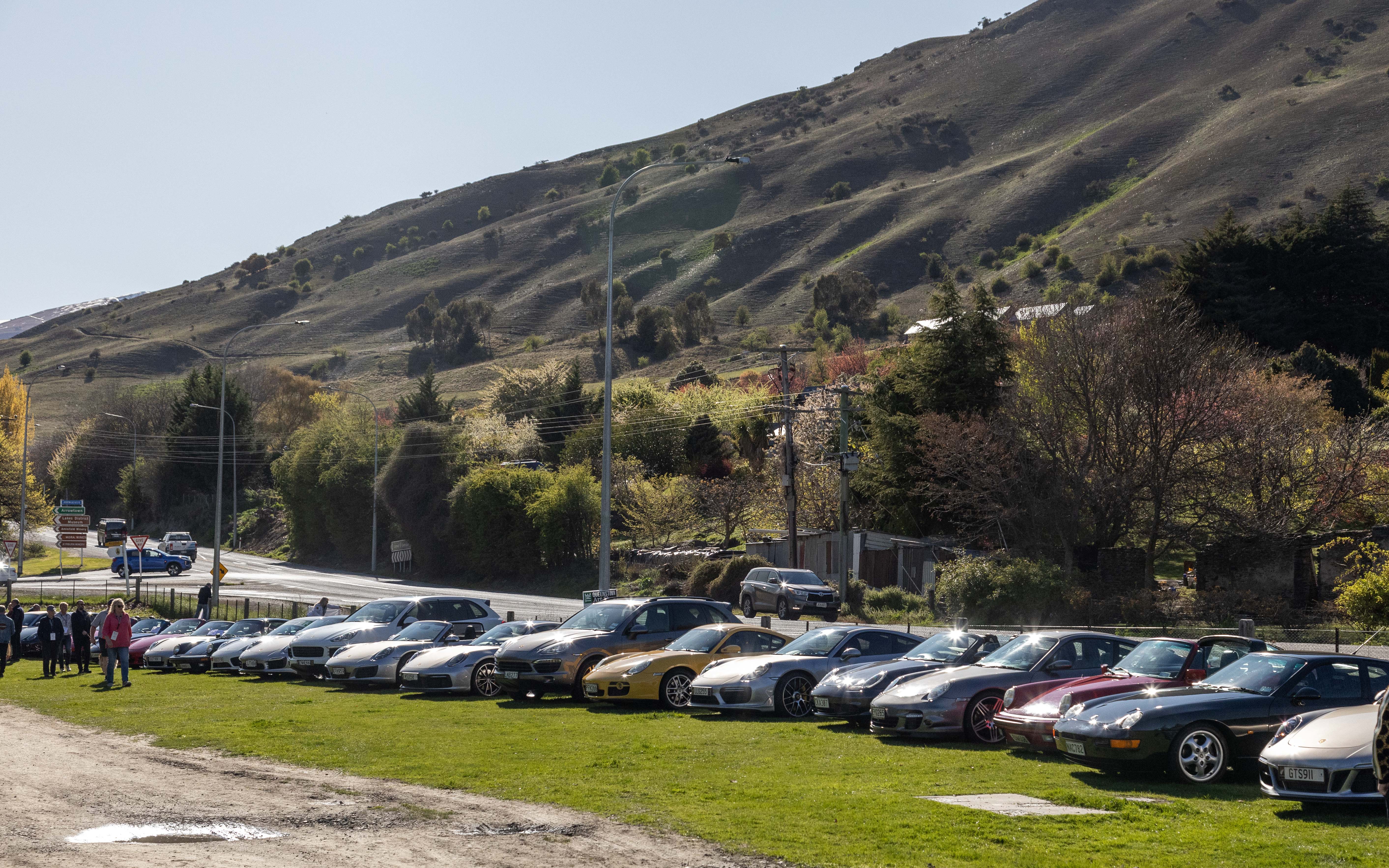 A lineup of gleaming Porsche cars parked up near Lake Hayes, as part of the Porsche Club NZ's...