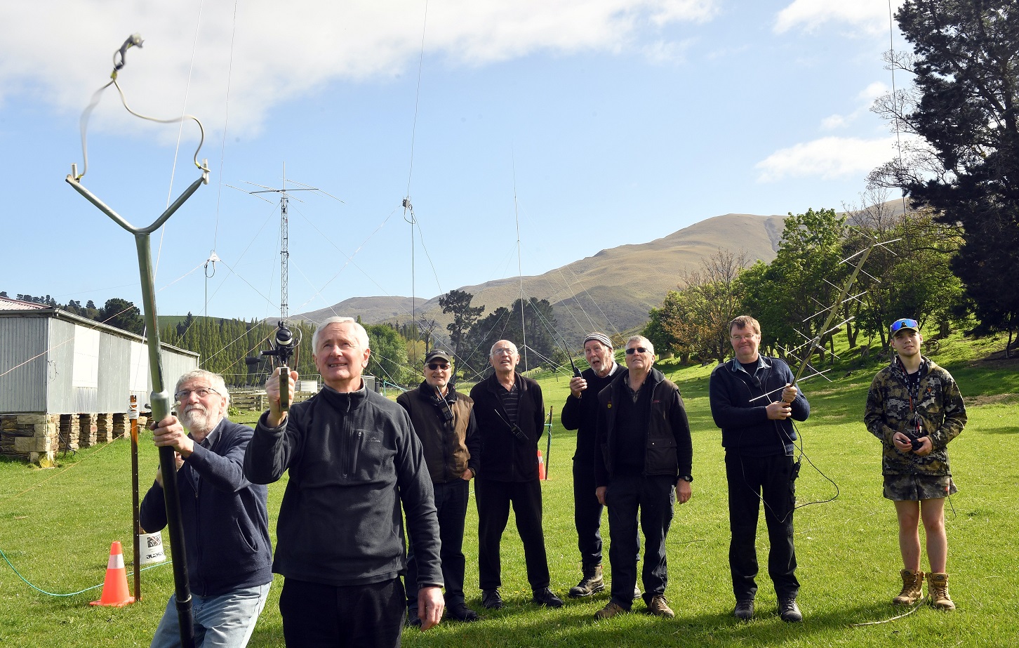 Amateur radio operators Mike McAlevey (left) and Greg Walsh (second from left) use a catapult and...