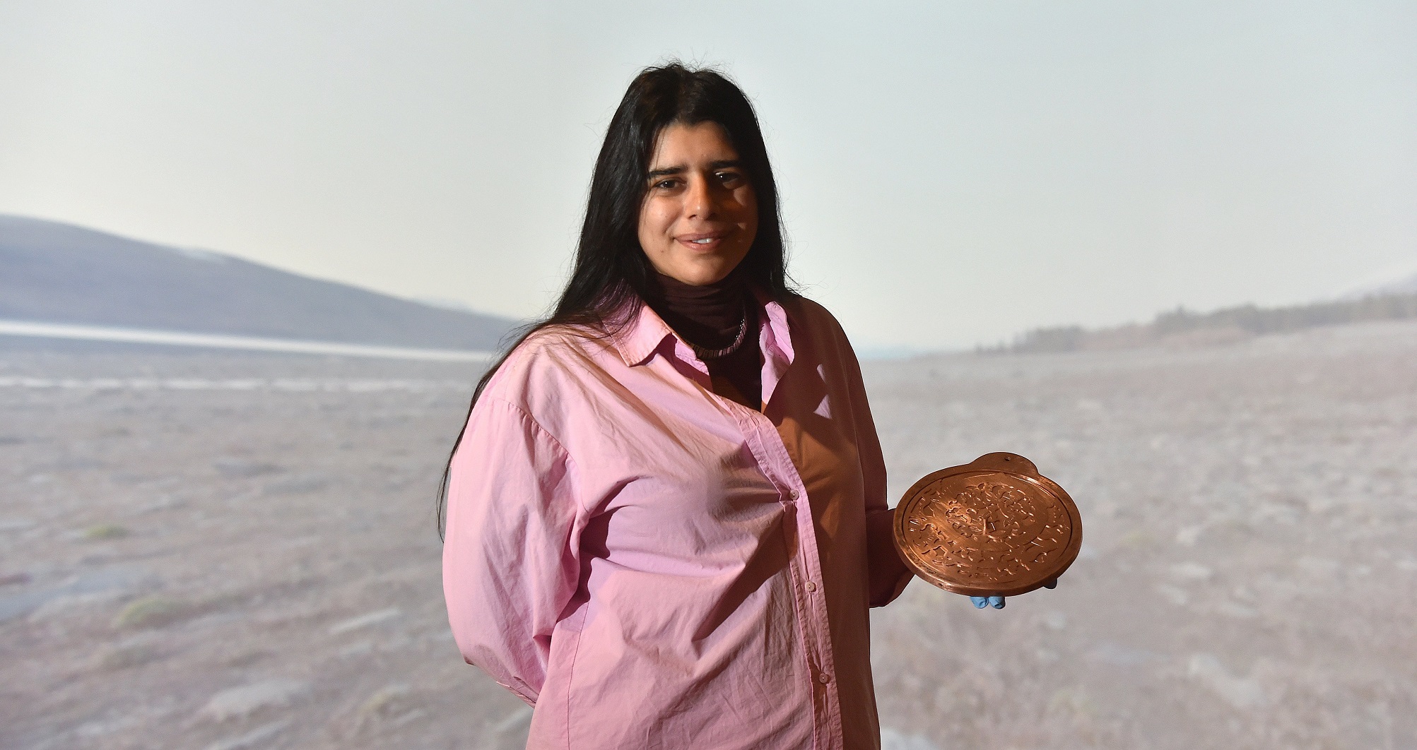 Shireen Taweel holds her work Southern Celestial Astrolabe (2024), hand pierced, engraved copper,...