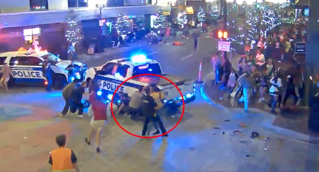 A police officer tries to detain a man after the shooting incident in Orlando in this screengrab...