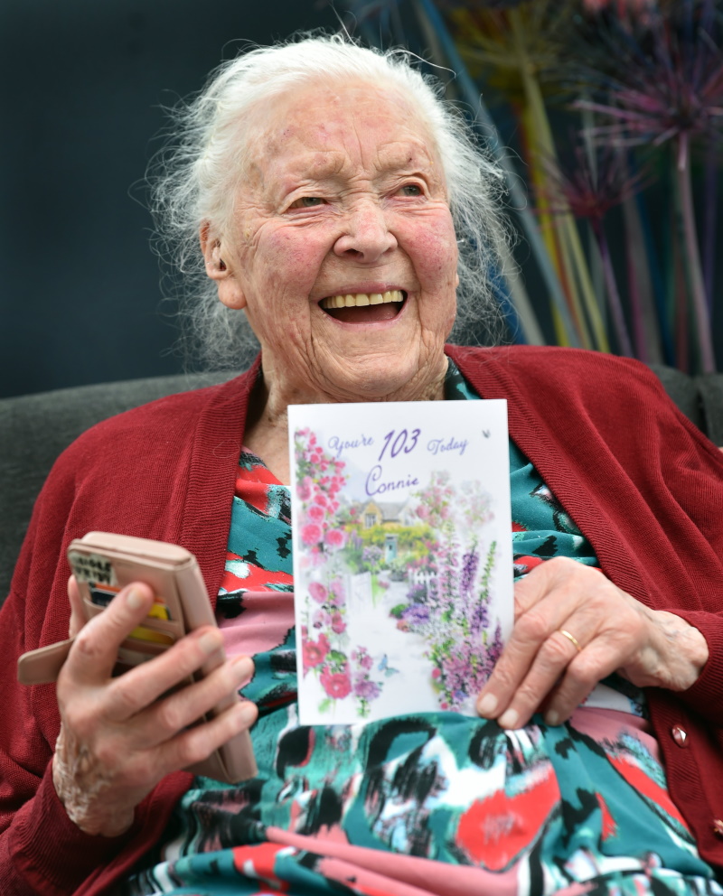 Connie Nelson with a birthday card and her prized mobile phone, celebrating her 103rd birthday at...