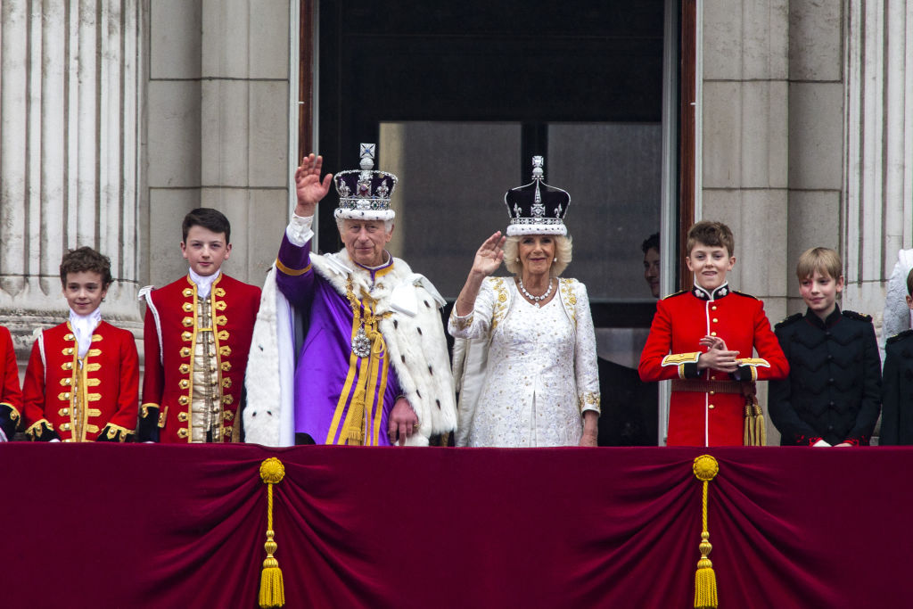 King Charles and Queen Camilla wave to the crowds from the Buckingham Palace balcony at last year...