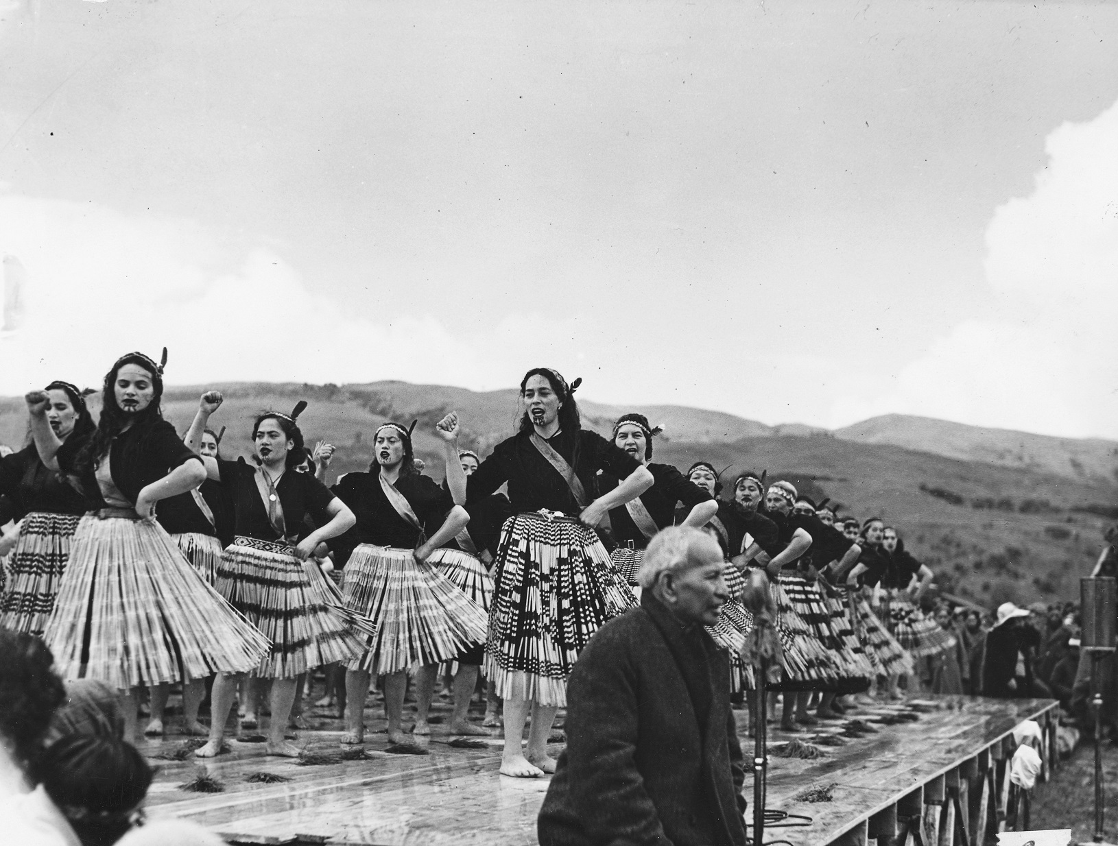 Wāhine Māori perform a waiata next to Sir Āpirana Ngata at the Victoria Cross ceremony for Te...