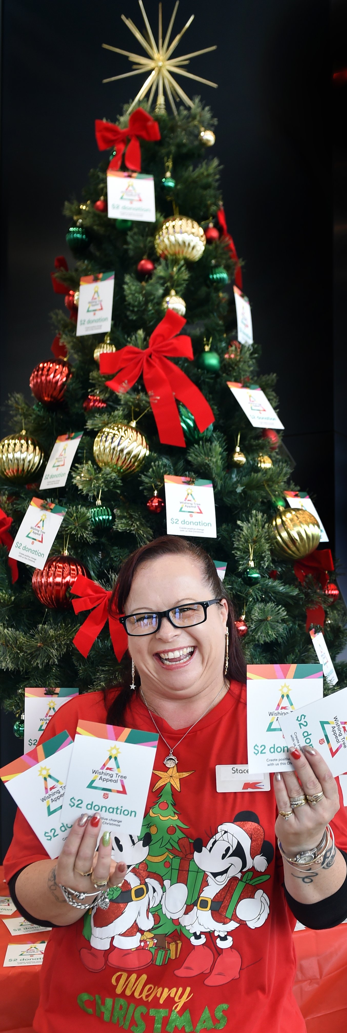 Stace Mitchell, of Kmart, flashes gift cards during the opening of the Wishing Tree Appeal at...