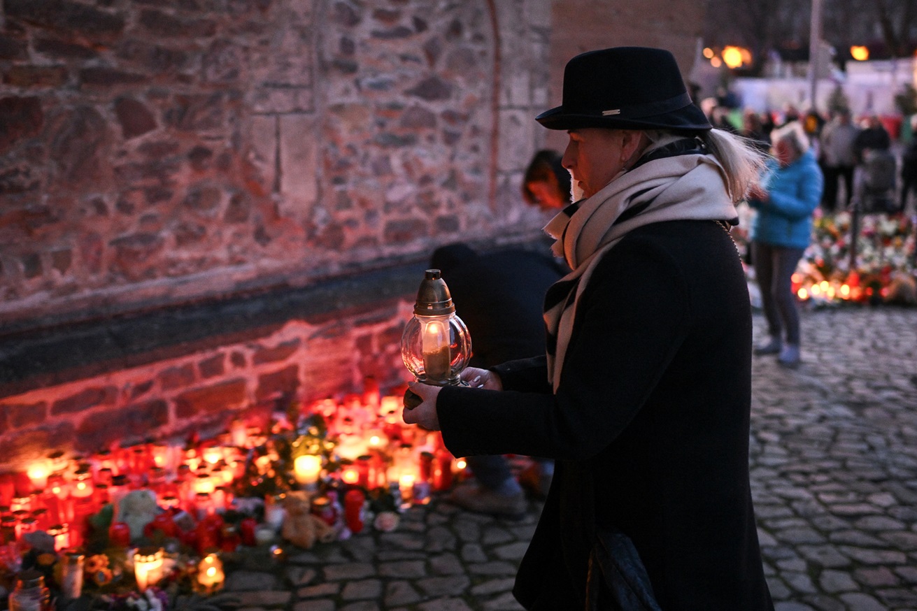 A woman holds a candle as people pay tribute to the victims of the Christmas market attack in...