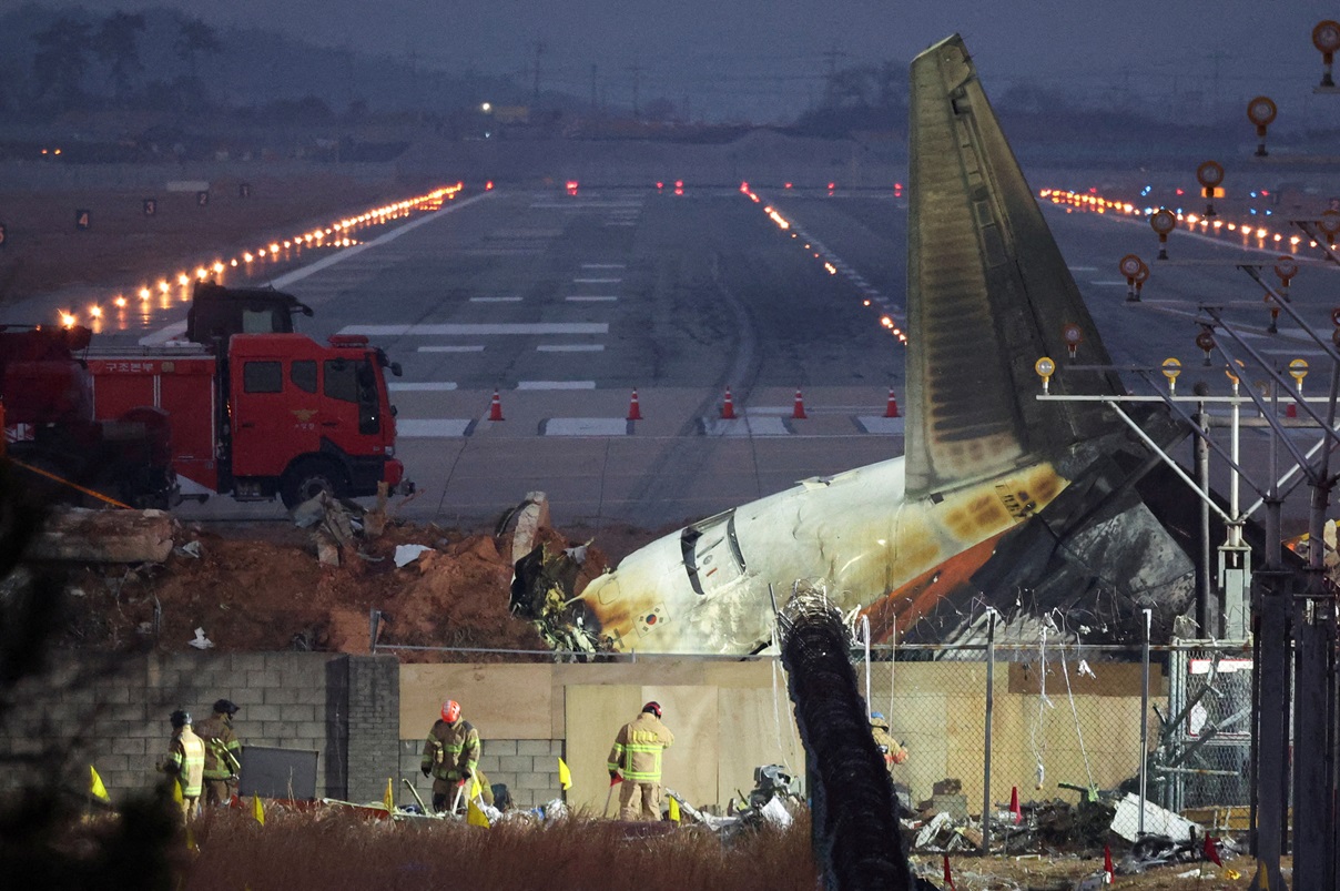 Rescuers work near the wreckage of the Jeju Air aircraft that went off the runway and crashed at...