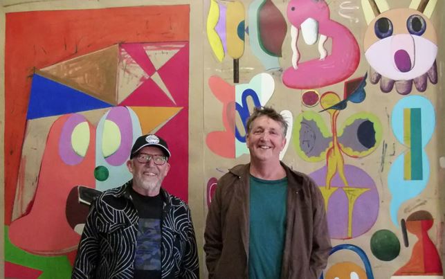 Artist Mark Braunias, right, in front of one of his paintings with art collector Chris Parkin....