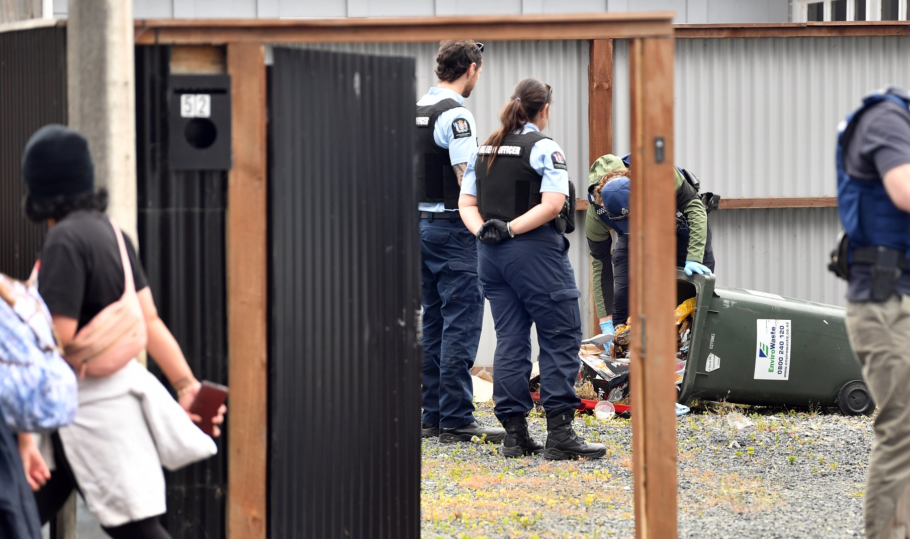 Fisheries officers watch as a policeman empties a rubbish bin during a search at a King Cobras...