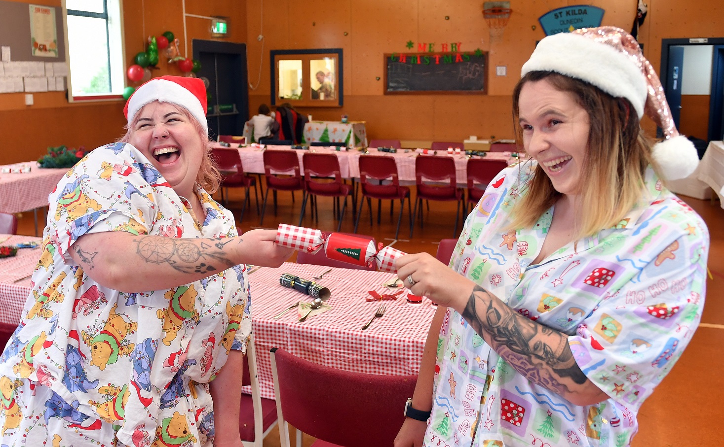 Cousins (from left) Celeste Sprague and Nicole O’Keefe pull a cracker at their very large family...