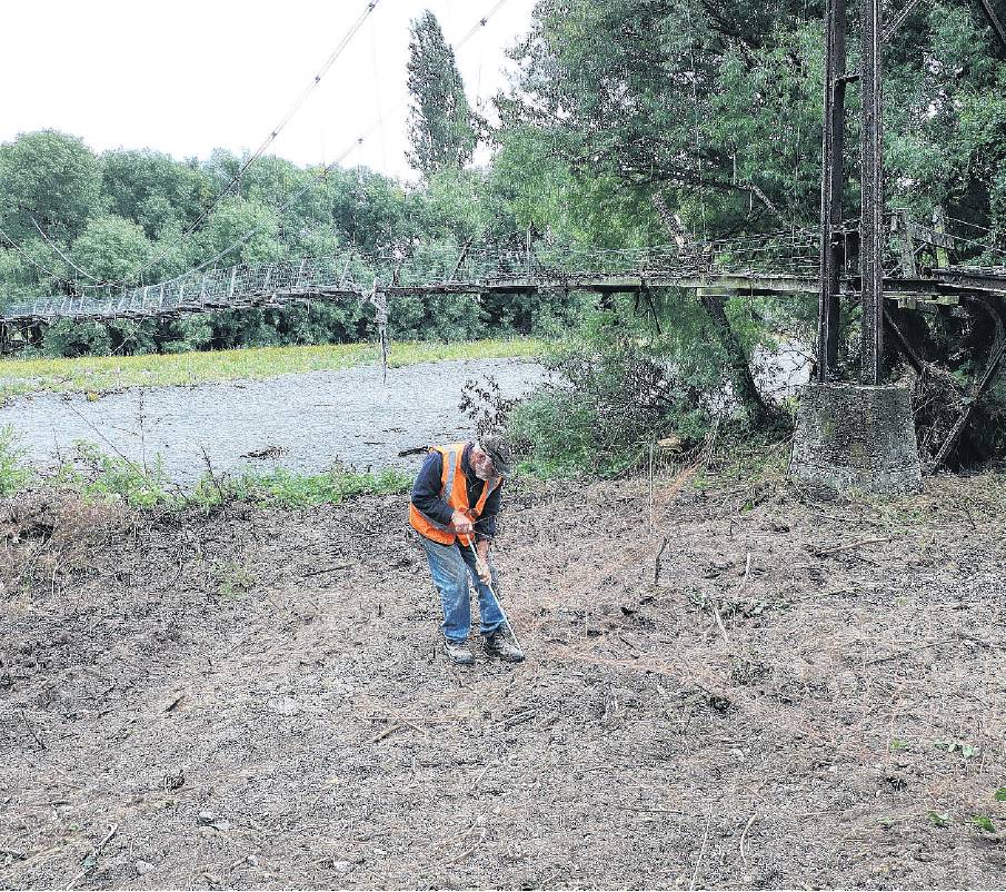 A volunteer works on removing scrub which had hidden the approach ramps for the Wolffs Road...