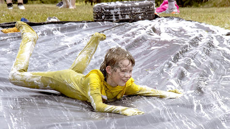 Lakyn McDougall, 11, from South New Brighton School slides down the last obstacle before crossing...