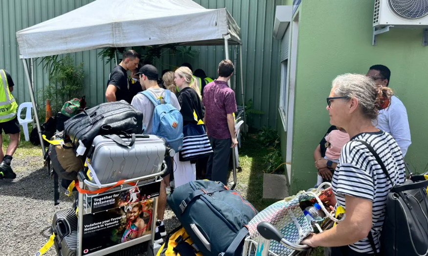 People queue at Port Vila's airport for the last repatriation flight planned to New Zealand, as...