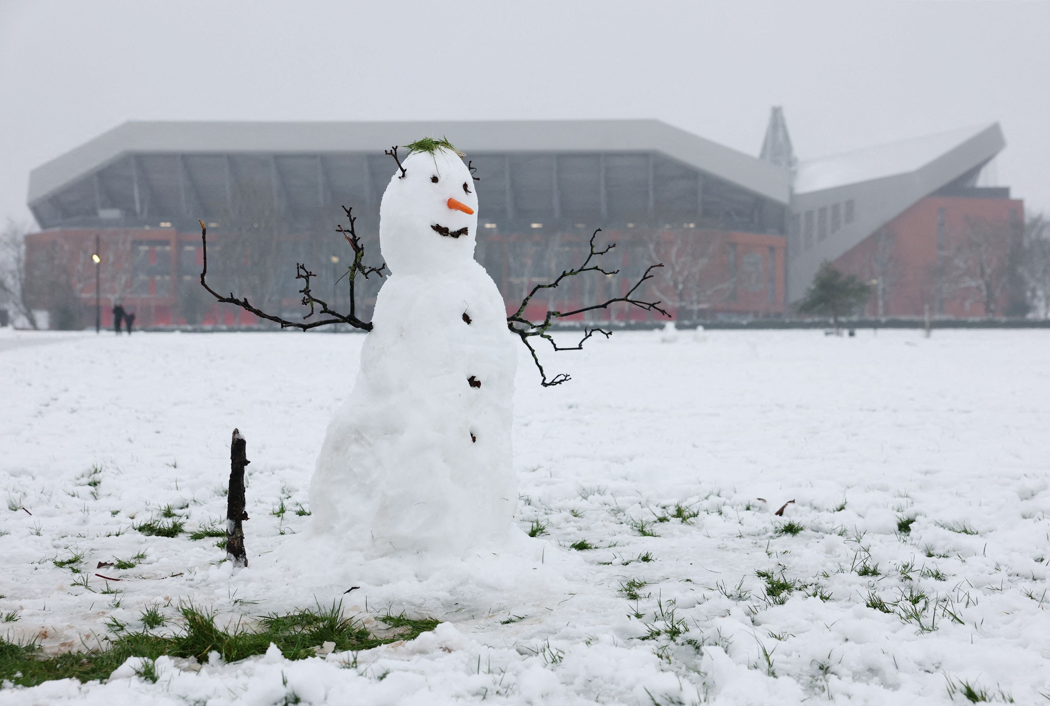 Nice day for it... A snowman stands outside Anfield before this week’s clash between English...