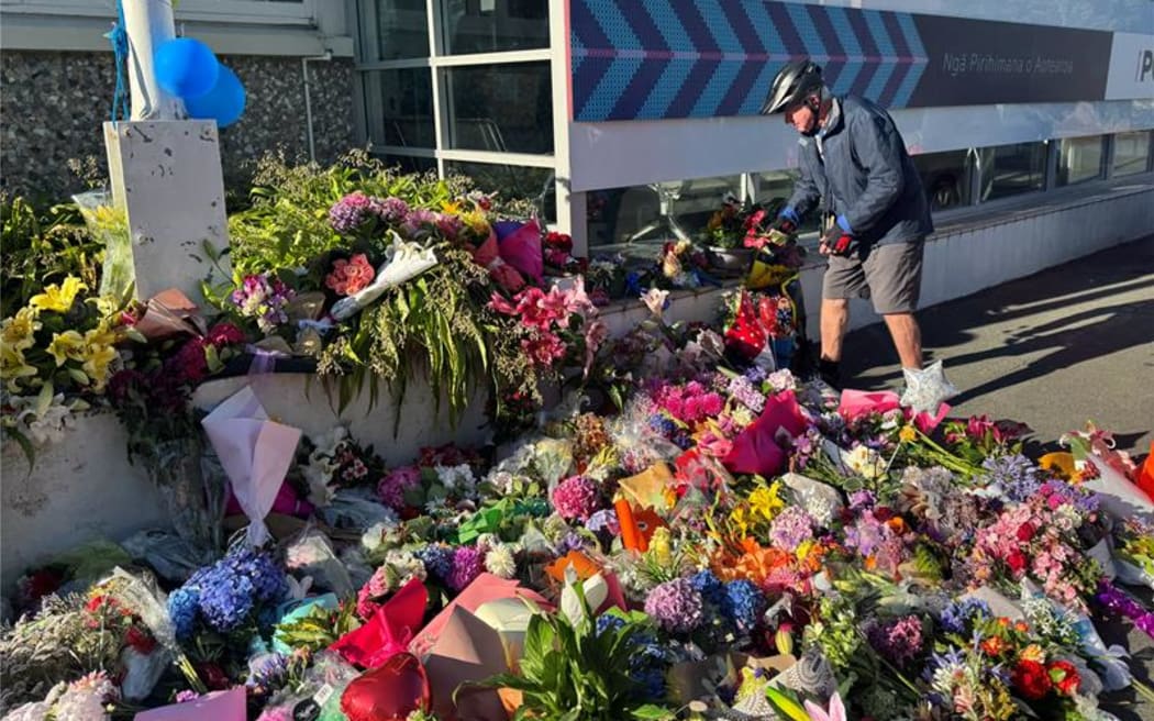 Scores of people leave flowers outside the Nelson Police Station on Friday morning. Photo: RNZ