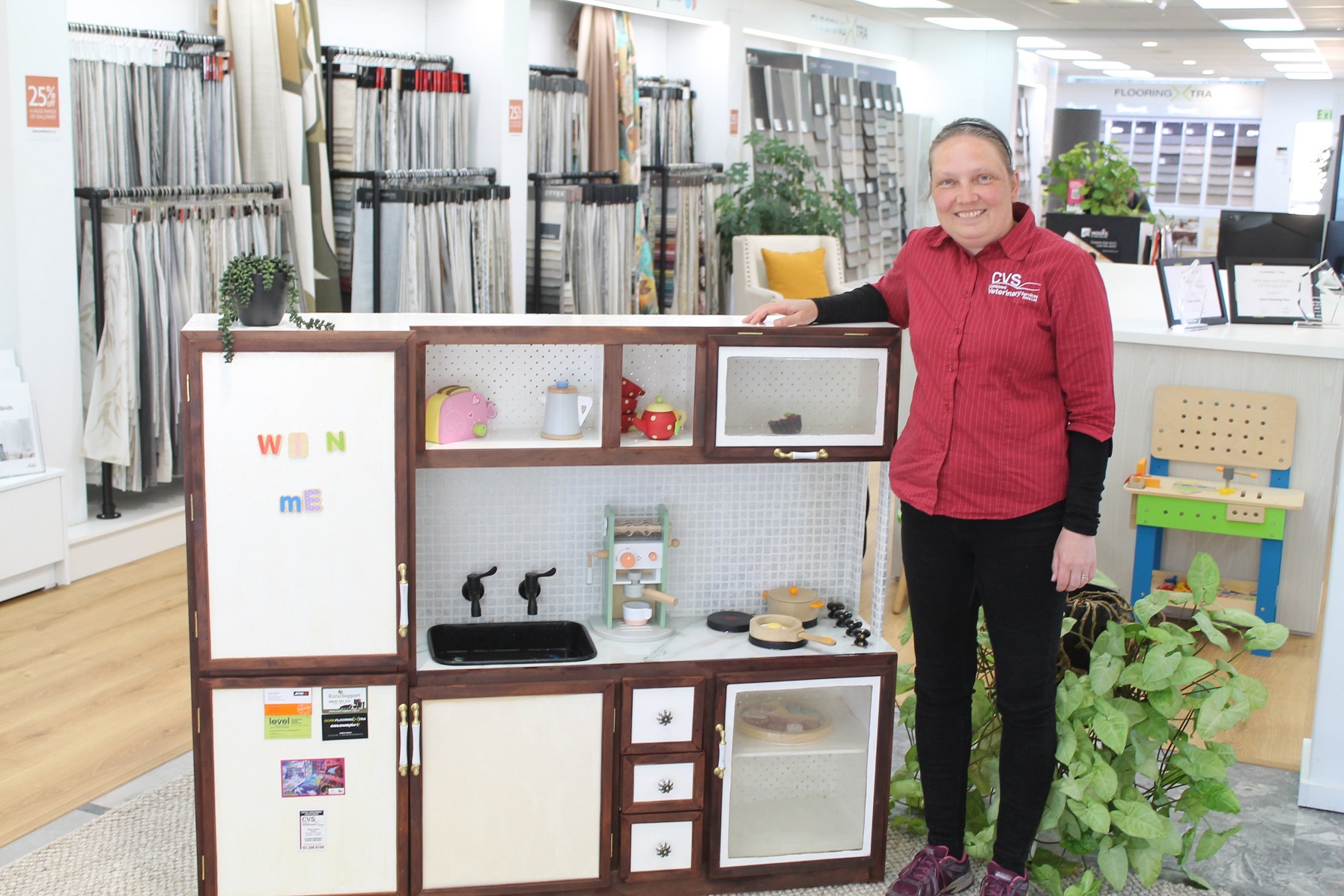 Woodworker Liv Gasland standing beside her creation, a toy kitchen, set to be raffled off at the...