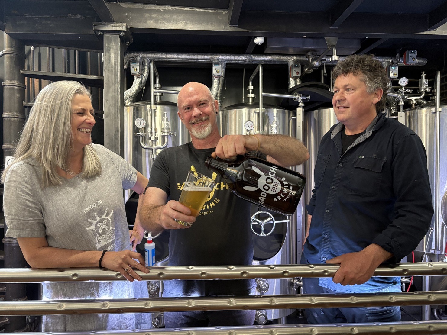 Gadoochi Brewery owners Nicola McGilvray and Chris Ellenden watch as brewer Damon Milne pours a...