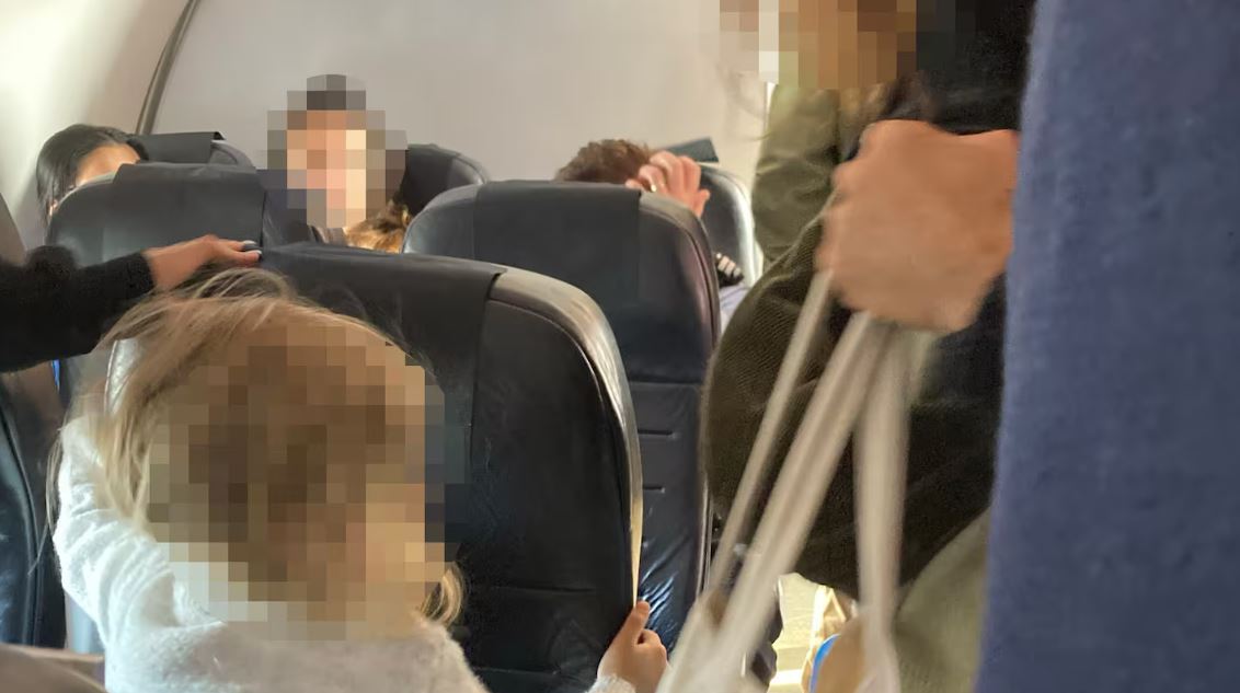 The handcuffed prisoner was seated at the back of the plane, near members of the public,...