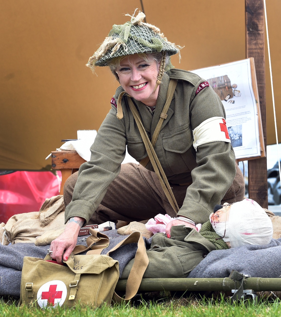 Dunedin Military Re-enactment Group member Rolien Ham-Geliefde attends to a wounded soldier at a...