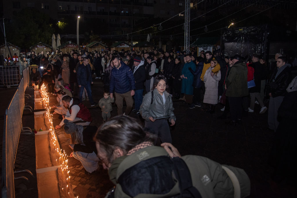 People gather to light candles in memory of people who lost their lives after the armed attacks...