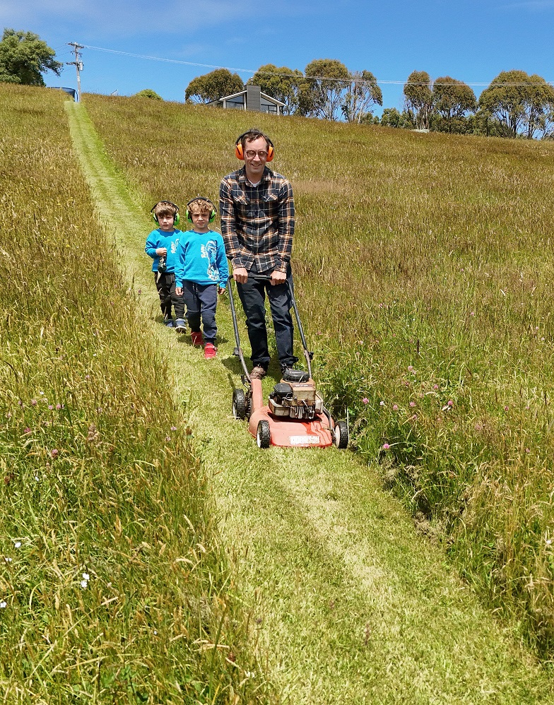 Dallas Venables is followed by his sons Archie, 6, and Sebastian, 3, as he mows a 500m-long path...