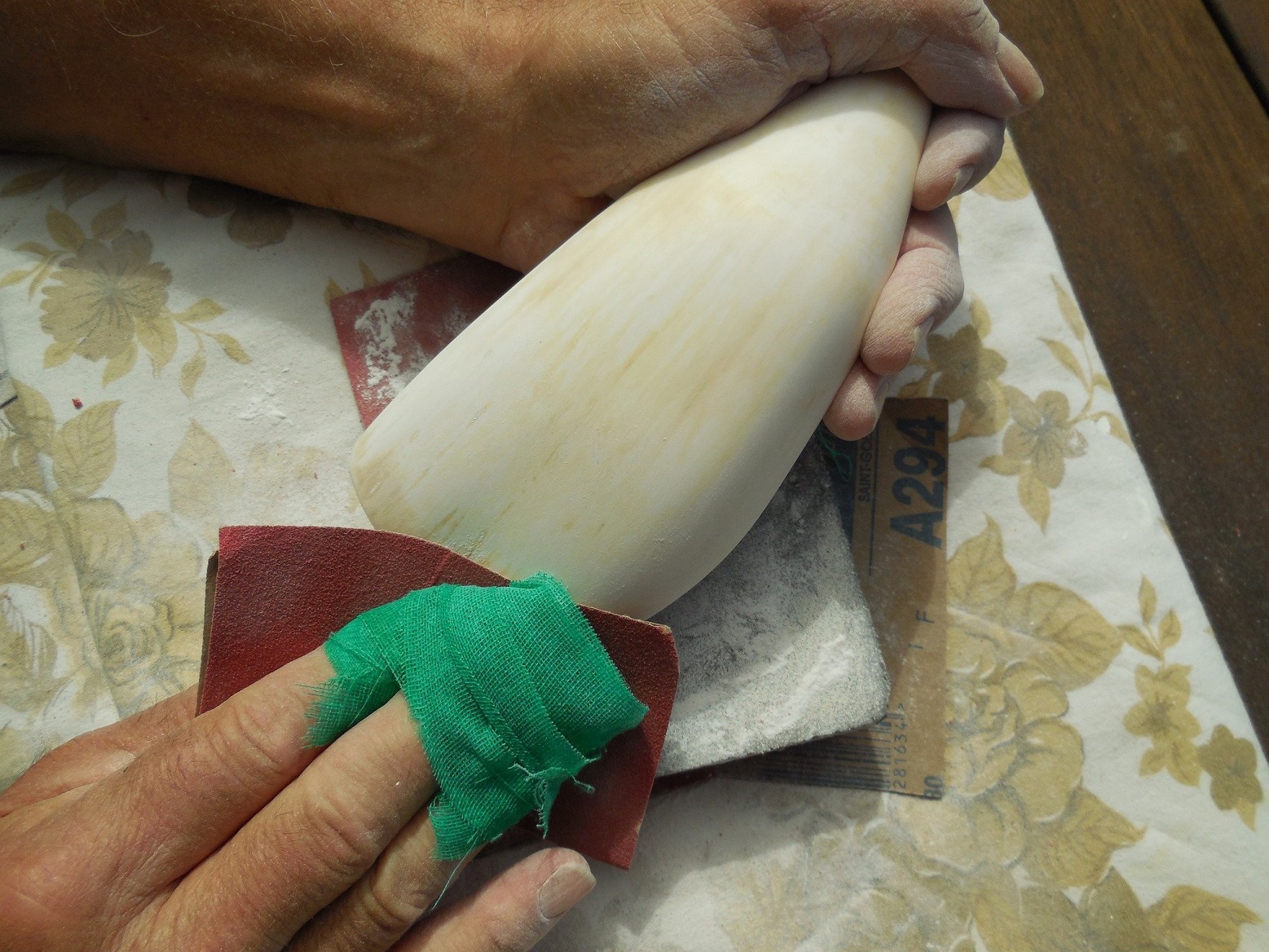 Gus Milne sands a whale tooth.