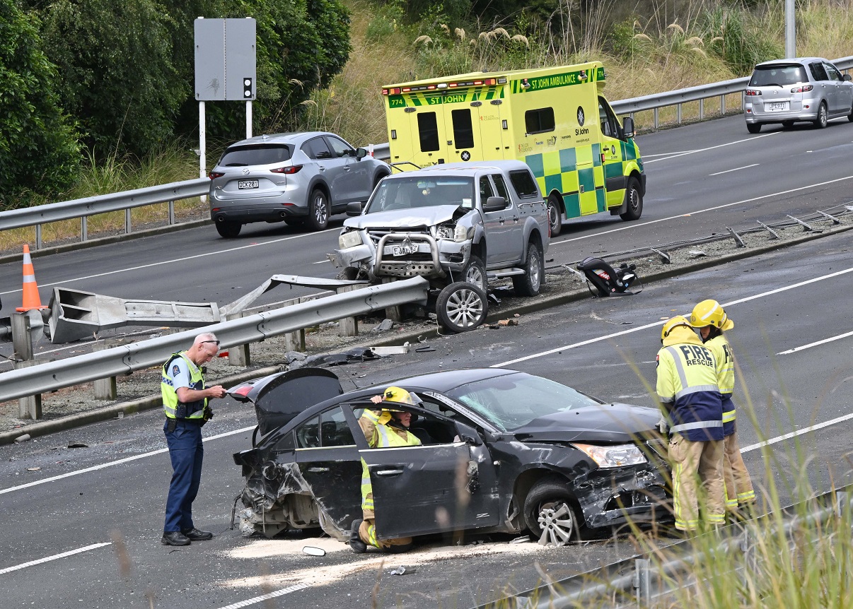 Emergency services personnel examine one of the vehicles involved in a two-car crash on the...