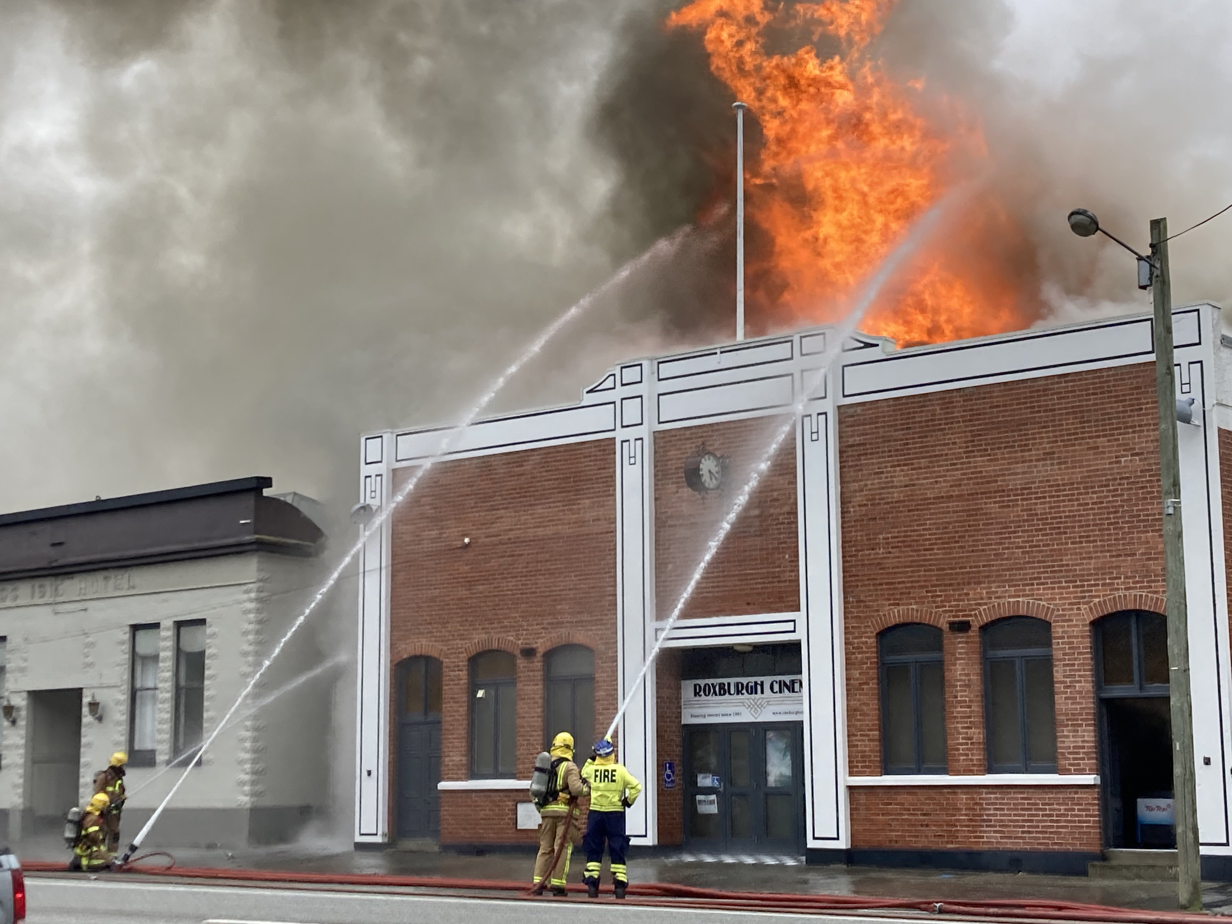 Firefighters attempt to quell flames leaping from the Roxburgh Town Hall yesterday afternoon. The...