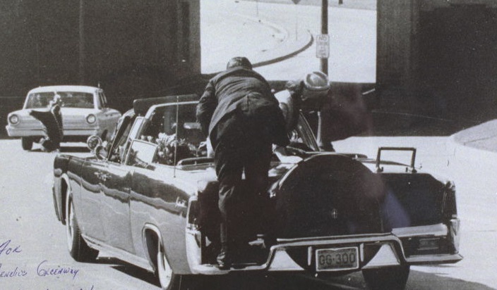 Clint Hill climbs into the car carrying a fatally shot President John F Kennedy and his wife...