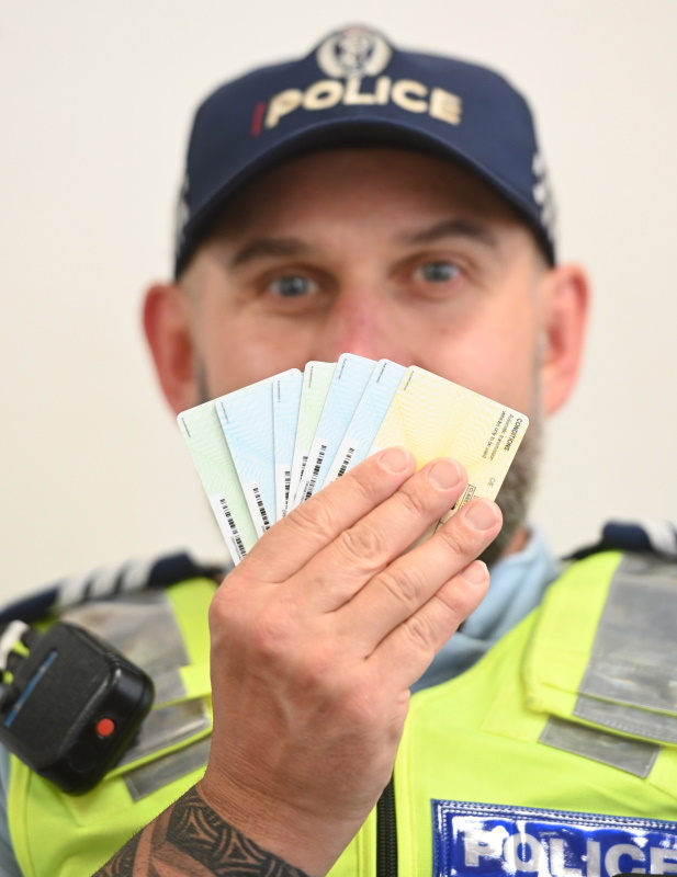 Dunedin Police Sergeant Steve Jones holds doctored/altered ids at the Police Station. Photo:...