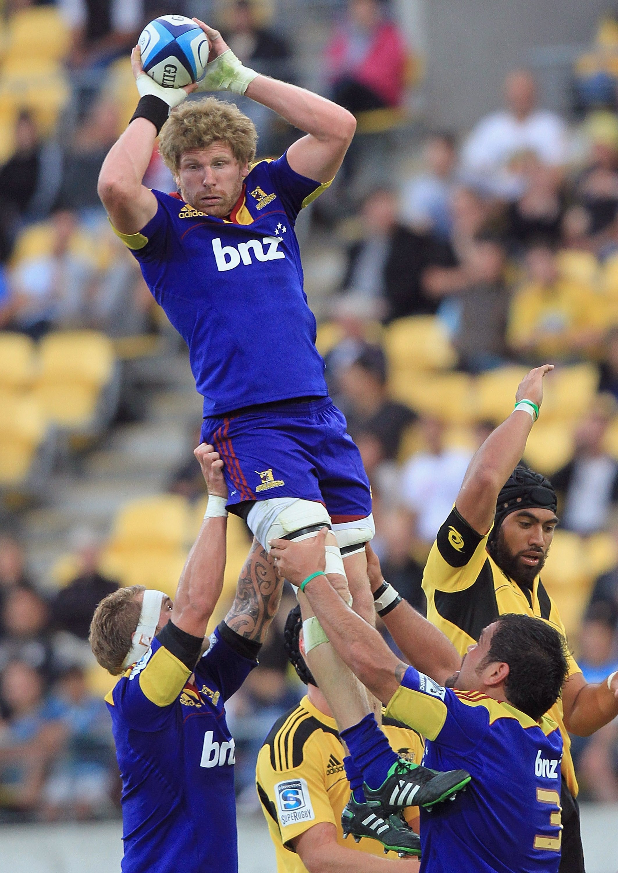 Highlanders flanker Adam Thomson is hoisted in a lineout by team-mates Jarrad Hoeata (left) and...