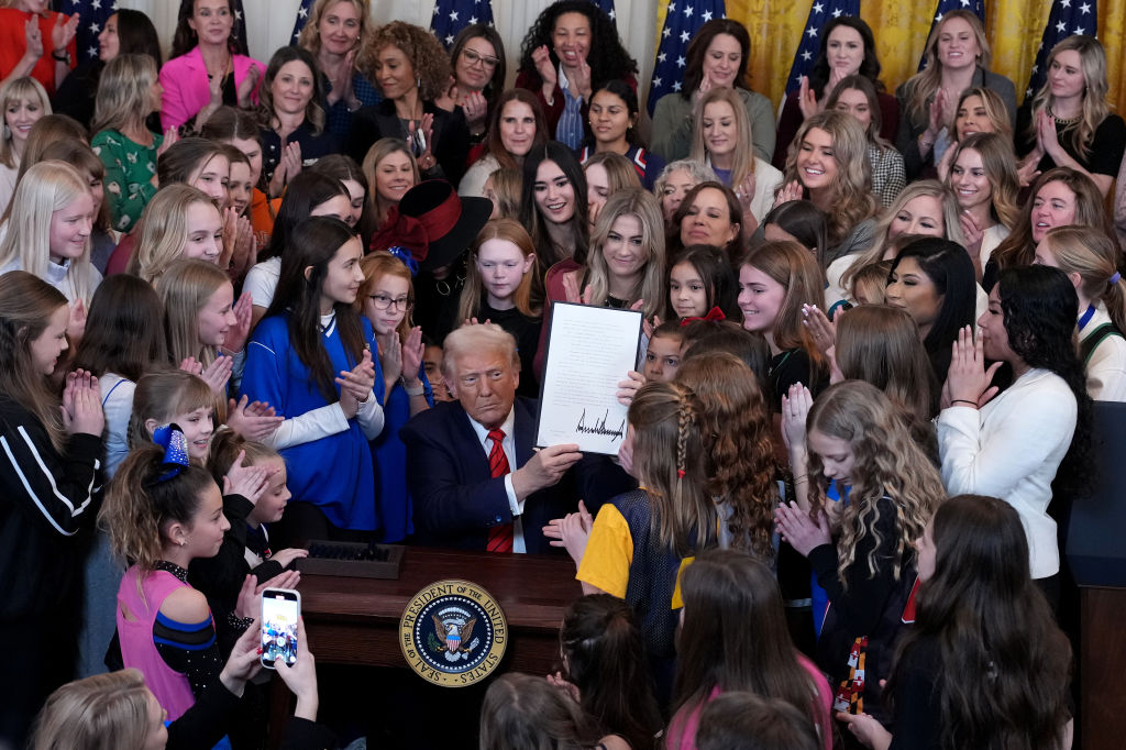 US President Donald Trump signs the “No Men in Women’s Sports” executive order surrounded by...