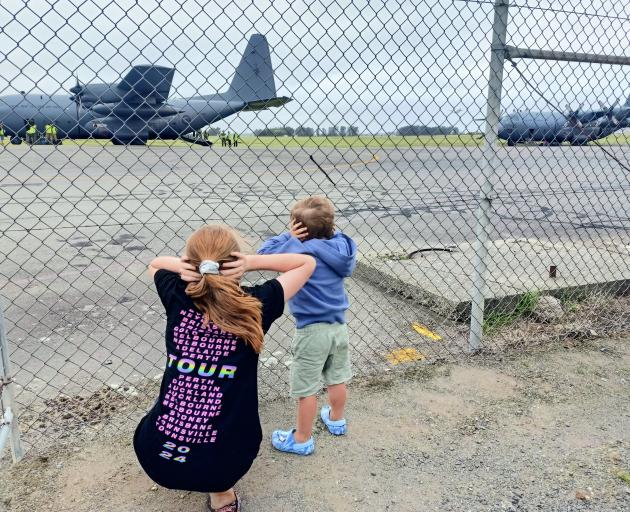 Grayce, 13, and Quinn, 3, Padget protect their ears against the noise of the three Royal New...