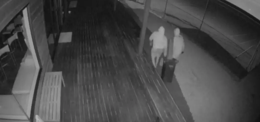 CCTV footage shows two people taking the honesty box away in a rubbish bin. Photo: Supplied