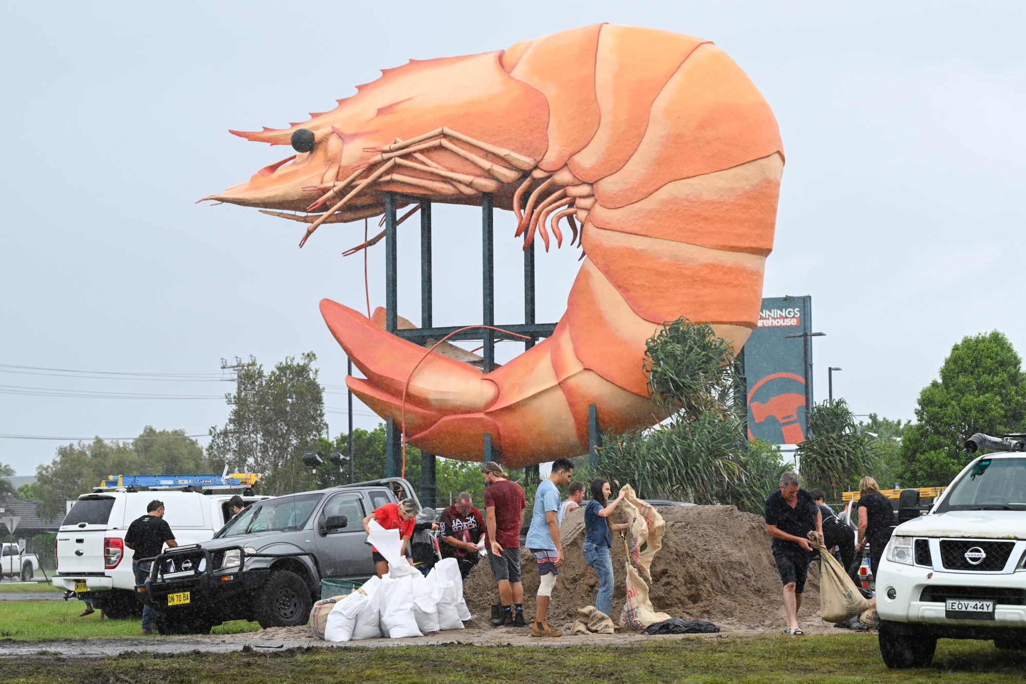 People fill up sandbags beside the Big Prawn in the town of Ballina in New South Wales ahead of...