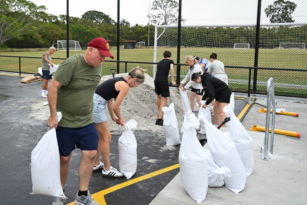 Members of Eastern Suburbs Soccer Club fill sandbags at Heath Park in Brisbane as parts of...