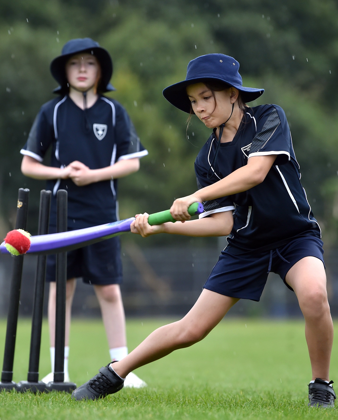 Sacred Heart school pupil Becky Chao, 10, slices the ball over the covers as her classmate...