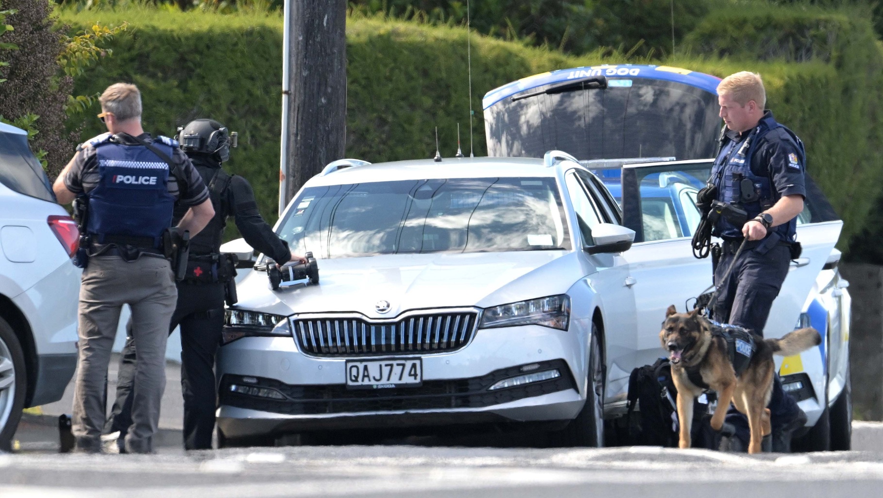 An armed offenders squad member readies a remotely operated vehicle outside a house in Taieri Rd,...