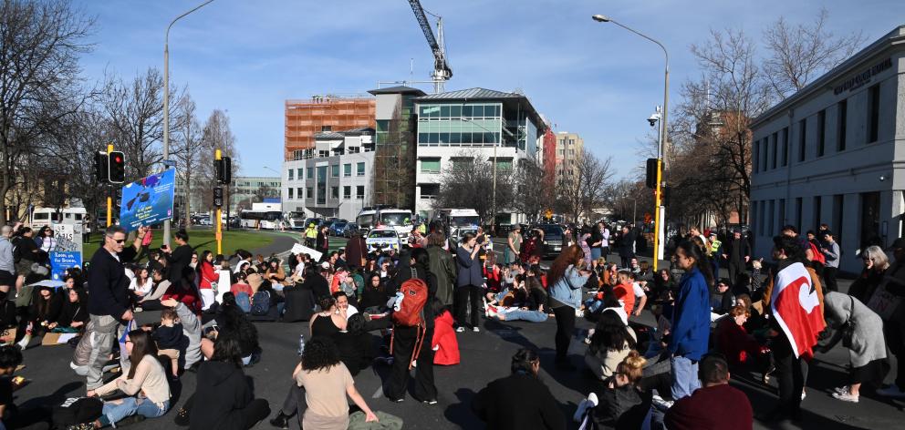 Protesters sit in the middle of State Highway 1 at the intersection of Albany and Cumberland Sts....