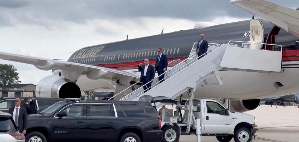 Donald Trump gestures as he arrives at Milwaukee Mitchell International Airport a day after...