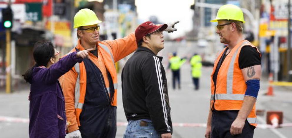 Safety workers talk to business owners after the 2010 earthquake. Photo: Getty Images