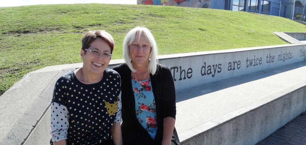 Poems in the Waiting Room co-ordinator Ruth Arnison (left) and artist Sheryl McCammon enjoy the poem Dunedin Summer, by the late Jean Lonie, which adorns the concrete seating/steps in front of the South Coast Boardriders clubrooms at St Clair. 