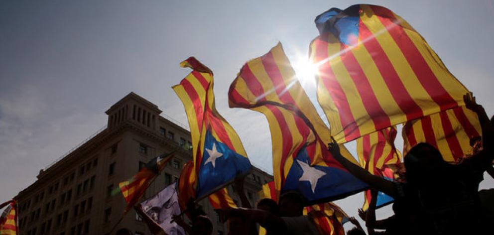 People hold on to Catalan separatist flags on top of an air vent during a demonstration two days after the banned independence referendum in Barcelona. Photo: Reuters