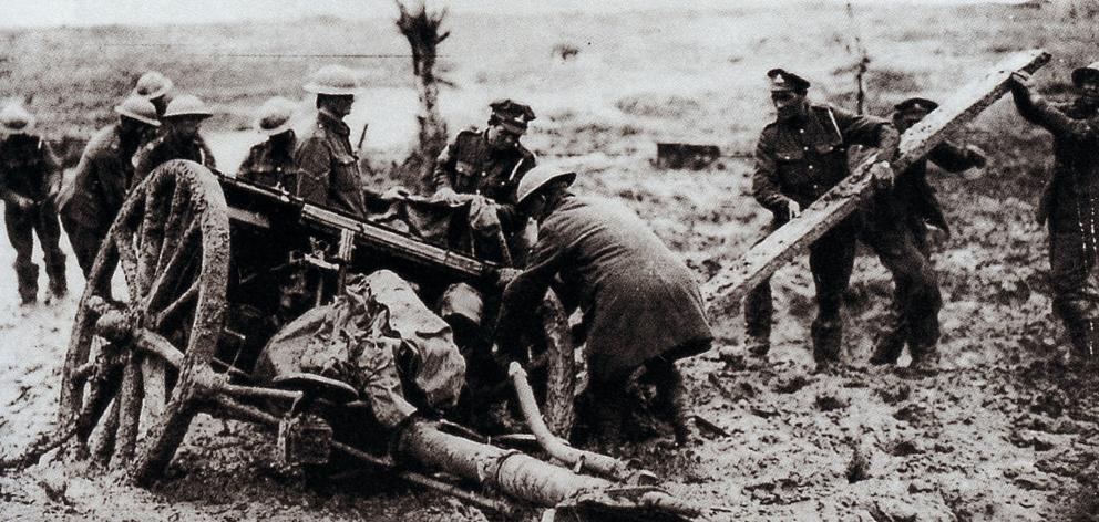 Soldiers try to free a field gun stuck in the mud.