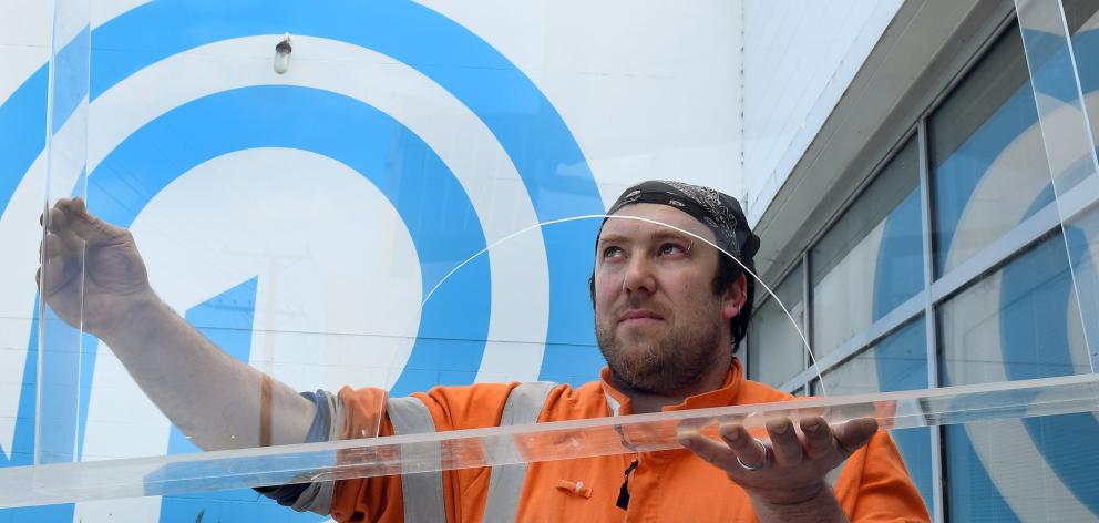 Hayden Kelliher checks on one of the many protective screens he has been making at Progressive...